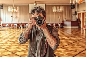 Man taking a photograph in a school gym